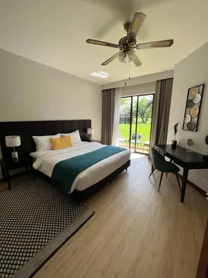 a bedroom with a bed with a ceiling fan and a desk at Allamanda 3 Laguna Phuket by Star in Laguna Phuket