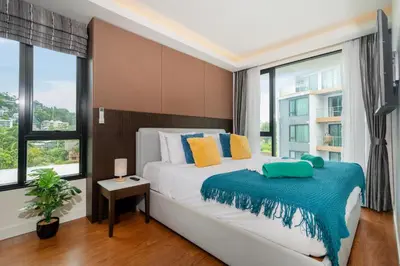 a bedroom with a bed and a large window at 1 Bedroom Apartment - The Aristo Resort by HCR in Surin Beach