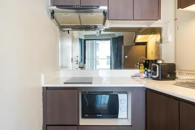 a kitchen with a counter top with a microwave at 1 Bedroom Apartment - The Aristo Resort by HCR in Surin Beach
