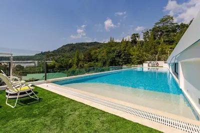 a swimming pool with a view of a house at Cozy New 1-Bedroom Apartment with Pool, 5 Min Walk to Kamala Beach in Kamala Beach