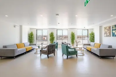 a large room with couches and tables and windows at Cozy New 1-Bedroom Apartment with Pool, 5 Min Walk to Kamala Beach in Kamala Beach