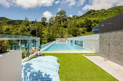a swimming pool on the side of a house at Cozy New 1-Bedroom Apartment with Pool, 5 Min Walk to Kamala Beach in Kamala Beach