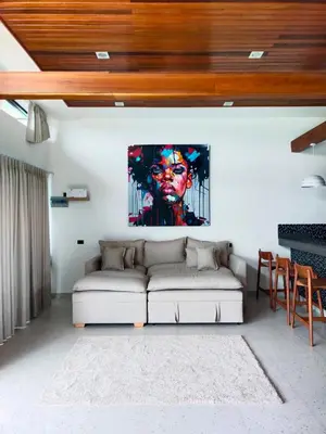 a living room with a couch and a painting on the wall at Rawai Villa in Rawai Beach