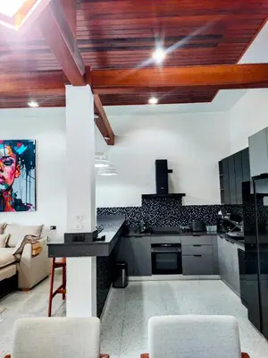 a kitchen with wooden ceilings and a living room at Rawai Villa in Rawai Beach