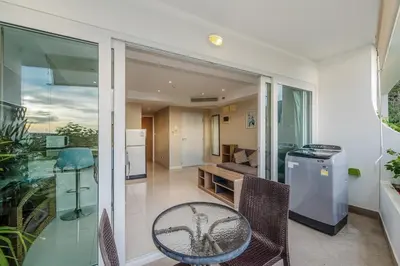 a balcony with a table and chairs and a kitchen at C195 Romantic 1BR Ocean Views Cozy & Bright in Kata Beach