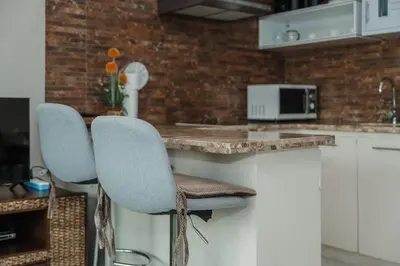 a kitchen with two chairs at a counter at C195 Romantic 1BR Ocean Views Cozy & Bright in Kata Beach