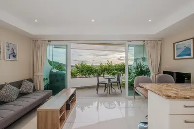 a living room with a couch and a table at C195 Romantic 1BR Ocean Views Cozy & Bright in Kata Beach