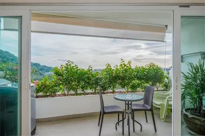 a balcony with a table and chairs and a view at C195 Romantic 1BR Ocean Views Cozy & Bright in Kata Beach