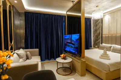 a room with a bed and a tv and a couch at New 1 Bdr Bellevue Lagoon Bang-Tao Beach in Laguna Phuket