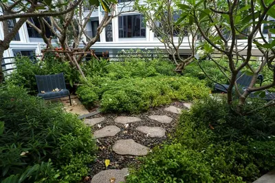 a garden with rocks and plants and a bench at New 1 Bdr Bellevue Lagoon Bang-Tao Beach in Laguna Phuket