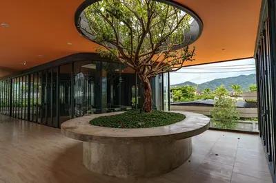 a tree in a large room with a building at New 1 Bdr Bellevue Lagoon Bang-Tao Beach in Laguna Phuket