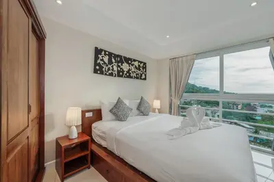 a bedroom with two beds and a large window at C196 Condo 1BR Sea View & 5 Min to Beach in Kata Beach
