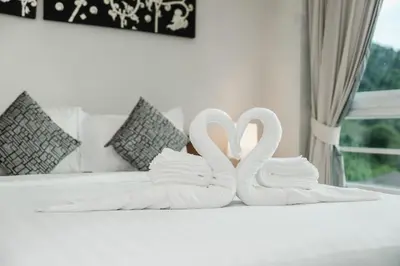 two white swans sitting on top of a bed at C196 Condo 1BR Sea View & 5 Min to Beach in Kata Beach