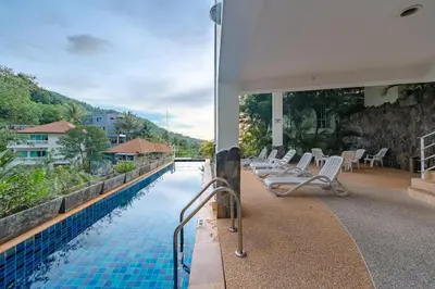 a swimming pool with lounge chairs next to a house at C196 Condo 1BR Sea View & 5 Min to Beach in Kata Beach