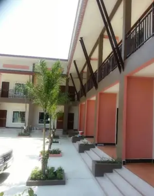 a building with a courtyard with palm trees in it at วันสมายล์ รีสอร์ท in Ban Klang