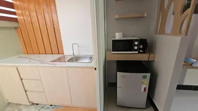 a small kitchen with a sink and a microwave at วันสมายล์ รีสอร์ท in Ban Klang