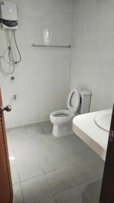 a white bathroom with a toilet and a sink at วันสมายล์ รีสอร์ท in Ban Klang