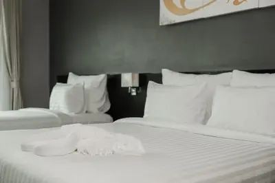 two beds in a hotel room with white sheets and pillows at C197 Condo 1BR with Pool 3 Min Walk to Beach in Patong Beach