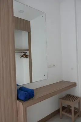 a dressing room with a mirror and a wooden bench at Lae Lay Suite in Karon Beach