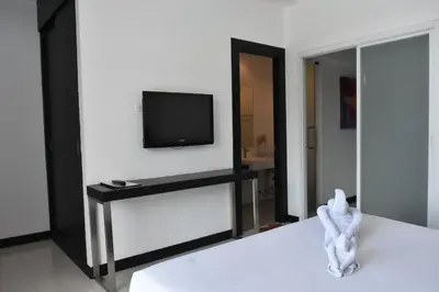 a living room with a tv and a mirror at Lae Lay Suite in Karon Beach