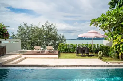 a pool with a table and chairs and an umbrella at \u62c9\u5a01Eva4 \u4e09\u5367\u5ba4\u4e00\u7ebf\u6d77\u666f\u522b\u5885 \u8fd1\u62c9\u5a01\u6d77\u9c9c\u5e02\u573a \u8d85\u5e02 24\u5c0f\u65f6\u5c0f\u533a\u5b89\u4fdd in Ban Saiyuan (1)