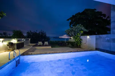 a swimming pool in a house at night at \u62c9\u5a01Eva4 \u4e09\u5367\u5ba4\u4e00\u7ebf\u6d77\u666f\u522b\u5885 \u8fd1\u62c9\u5a01\u6d77\u9c9c\u5e02\u573a \u8d85\u5e02 24\u5c0f\u65f6\u5c0f\u533a\u5b89\u4fdd in Ban Saiyuan (1)