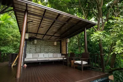 a covered deck with a couch and a table at Villa Lydia, Koh Yao Noi in Ko Yao Noi