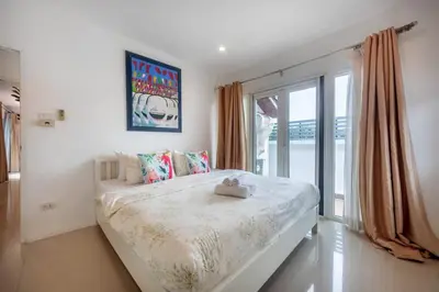 a bedroom with a large bed and a window at 3 Bedroom Pool Villa 5kms from Patong in Kathu