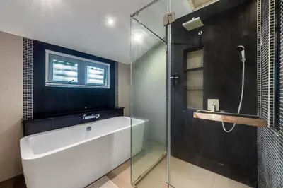 a bathroom with a glass shower and a tub at 3 Bedroom Pool Villa 5kms from Patong in Kathu