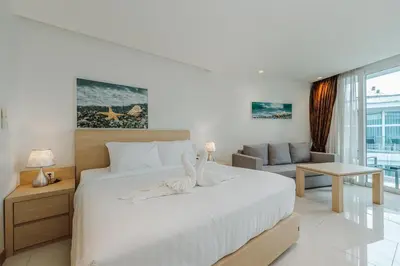 a bedroom with a large white bed and a couch at C198 Oceanview Stay Gym, Pool & Walk to Beach in Rawai Beach