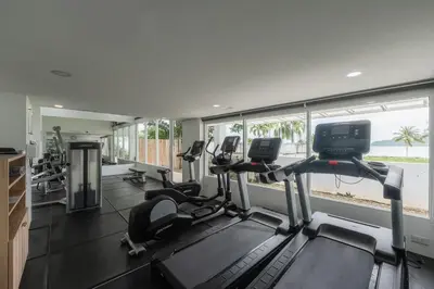 a gym with several treadmills and elliptical machines at C198 Oceanview Stay Gym, Pool & Walk to Beach in Rawai Beach