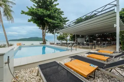 a swimming pool with tables and chairs next to the water at C198 Oceanview Stay Gym, Pool & Walk to Beach in Rawai Beach