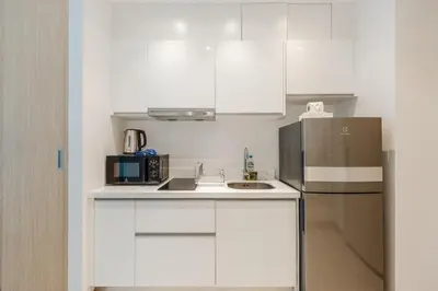 a kitchen with white cabinets and a refrigerator at C198 Oceanview Stay Gym, Pool & Walk to Beach in Rawai Beach