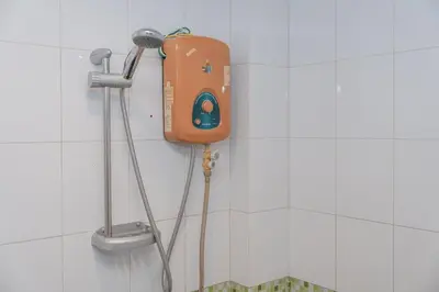 a shower in a tiled bathroom with an orange item on the wall at C199 Condo 1BR Walk to Lake, Beach, Bars & Market in Rawai Beach