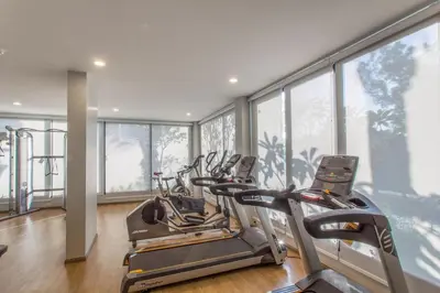 a gym with three cardio machines in a room with windows at B9 Ватсап669З5В2I976 in Nai Yang Beach