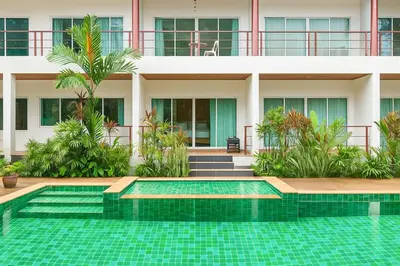 a house with a swimming pool in front of a building at C200 Relaxing 1BR Stay Walk to Nai Harn Beach in Rawai Beach