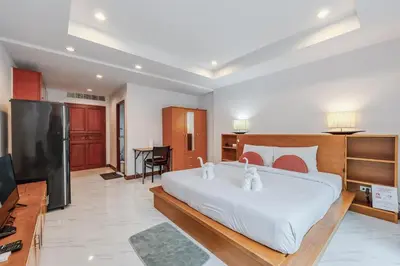 a bedroom with a large white bed and a flat screen tv at C200 Relaxing 1BR Stay Walk to Nai Harn Beach in Rawai Beach