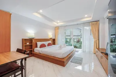 a bedroom with a bed and a desk and a television at C200 Relaxing 1BR Stay Walk to Nai Harn Beach in Rawai Beach