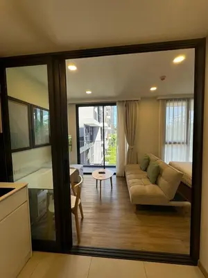 a living room with a couch and a table at Cozy studio Laguna SkyPark Phuket in Laguna Phuket