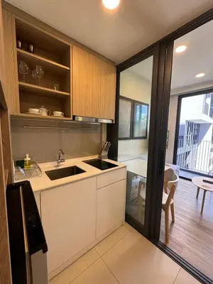 a kitchen with a sink and a dining room at Cozy studio Laguna SkyPark Phuket in Laguna Phuket
