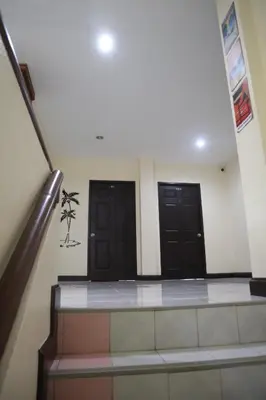 a hallway with two black doors in a building at Cocoloco hostel in Ban Khlong Haeng