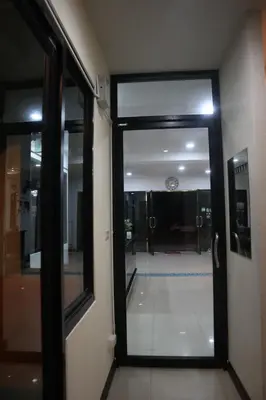 an open door to a hallway with a clock on the wall at Cocoloco hostel in Ban Khlong Haeng