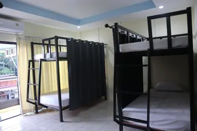 two bunk beds in a room with a window at Cocoloco hostel in Ban Khlong Haeng