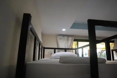 two bunk beds in a room with a window at Cocoloco hostel in Ban Khlong Haeng