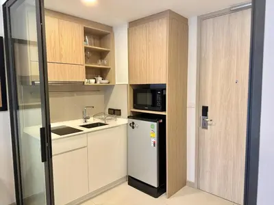 a kitchen with a refrigerator and a microwave at Laguna SkyPark by ShowProperty in Laguna Phuket