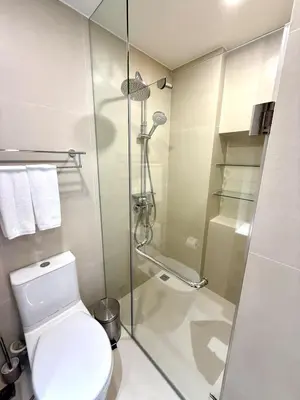 a bathroom with a toilet and a glass shower at Laguna SkyPark by ShowProperty in Laguna Phuket