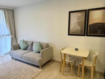 a living room with a couch and a table at Laguna SkyPark by ShowProperty in Laguna Phuket