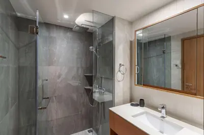 a bathroom with a shower and a sink and a mirror at Laguna Beachside by ShowProperty in Bang Tao Beach