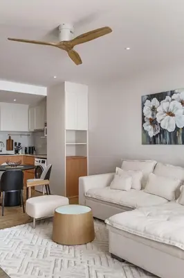 a living room with a couch and a ceiling fan at Laguna Beachside by ShowProperty in Bang Tao Beach