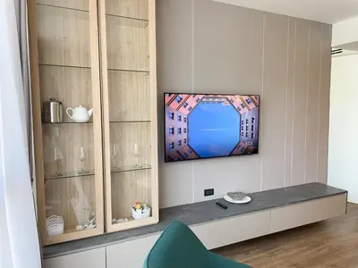 a living room with a tv on a wall at Layan Green Residence by ShowProperty in Layan Beach